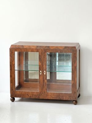 une armoire en bois avec des portes vitrées dans une pièce blanche