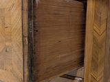 a wooden table with a drawer on it in front of a brick wall