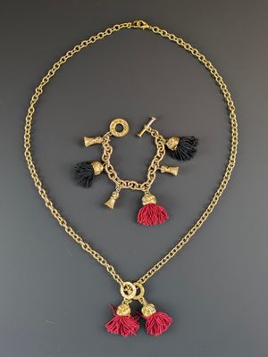 un ensemble composé d'un collier et de boucles d'oreilles ornés de pompons sur une chaîne