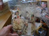 a person holding a doll in a box with other items in it