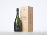 a bottle of champagne next to a wooden box on a table
