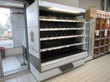 an empty refrigerator in the middle of a store