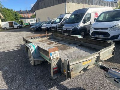 une remorque à plateau garée sur un parking