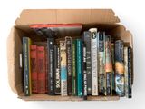 une boîte en carton remplie de livres posée sur une surface blanche
