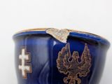 a blue vase with a gold decoration on it