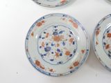three plates with orange and blue designs on them on a white surface