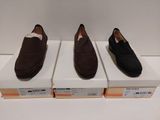 Trois paires de chaussures pour homme sont exposées dans une boîte