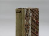 an old book sitting on top of a table covered in snow