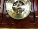 a clock with a barometer on the front of it