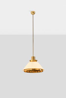 a brass pendant light with a white shade hanging from the ceiling