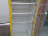 a yellow and white refrigerator that is outside on the street