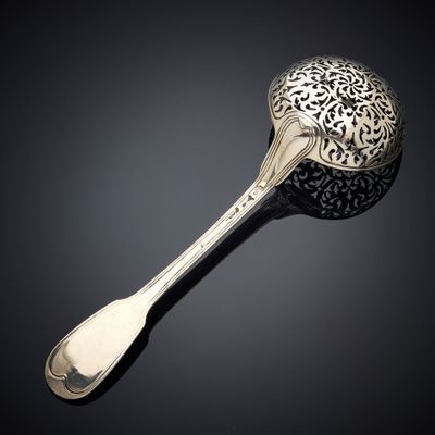 a silver spoon with a spoon handle on a black surface