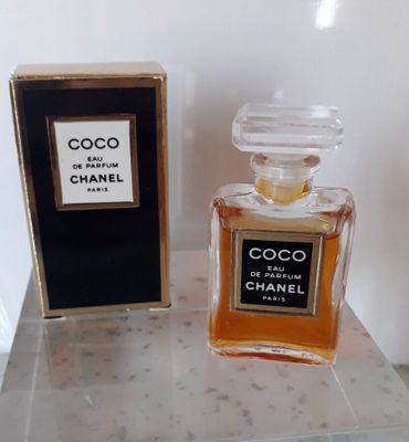 Flacon et coffret de l'eau de parfum Chanel Coco posés sur une table en marbre