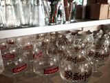 many wine glasses lined up on a shelf