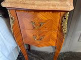 a small chest of drawers in the corner of a room