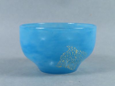 a blue glass bowl with a gold tree on it