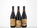 trois bouteilles de vin posées sur une table l'une à côté de l'autre