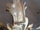 a metal sculpture of a bird on a table