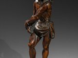 statue en bronze représentant un homme tenant une épée, posée sur un socle en bois