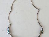 a close up of a necklace on a white surface