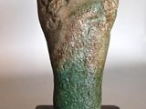 statue of a hand holding a small object on a wooden stand