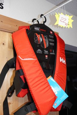 un gilet de sauvetage rouge accroché au mur à côté d'un sac à dos