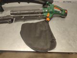 a green and black blow gun and a black bag on a table