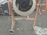 a cement mixer that is sitting on the ground