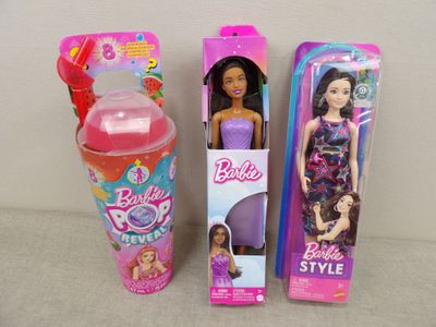 two barbie dolls are sitting next to each other on a table