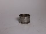gros plan d'une bague en argent sur une surface blanche