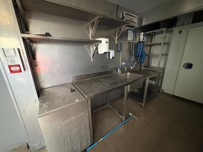 une cuisine équipée d'un évier, d'une cuisinière et d'étagères