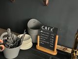 a black counter top with a chalk board and cups on it
