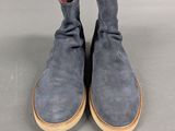 the back of a pair of blue sued boots on a gray surface