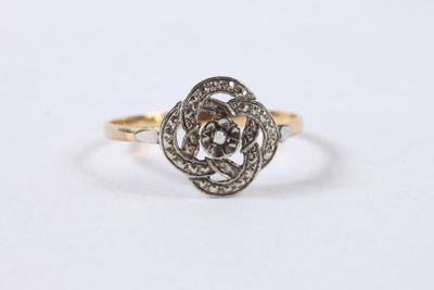 gros plan d'une bague en or et diamants sur fond blanc