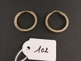two gold rings and a tag on a black surface