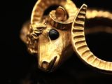 a close up of a gold ring with a ram ' s head on it