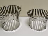 two silver vases sitting on top of a table next to each other