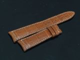 a close up of two brown leather straps on a black surface