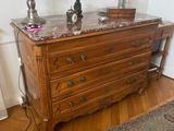 a dresser with a marble top and a lamp on it