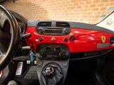 a red car dashboard with a steering wheel and dashboard buttons