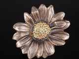 un gros plan d'une fleur en métal sur une surface noire