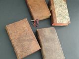 three old books sitting on top of a table next to each other