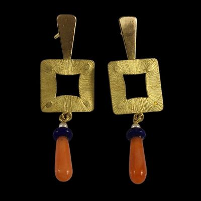 une photo d'une paire de boucles d'oreilles ornées de perles orange et bleues