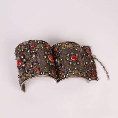 an old silver book with red and blue stones on it