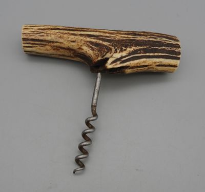 a close up of a bottle opener with a wooden handle