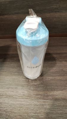 un biberon posé sur une table à côté d'une bouteille d'eau