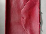 a close up of a red leather case on a white surface
