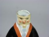 a ceramic figurine of a man wearing a suit and tie