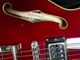 a close up of a red electric guitar on display