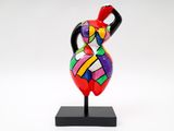a close up of a colorful vase on a stand on a white background